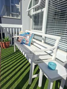 a white bench sitting on top of a porch at 7onthebeach unit 3 in Jeffreys Bay
