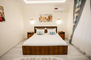 a bedroom with a bed with white sheets and pillows at Mahalla Old City Samarkand in Samarkand