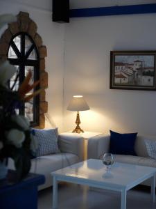 a living room with a white couch and a table at Hilltop Gardens Hotel Apartments in Paphos City