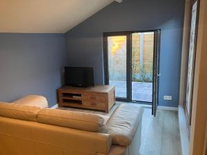a living room with a couch and a tv at The Tiny House in Nieuwpoort