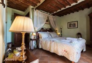 a bedroom with a bed and a lamp on a table at Borgo Tepolini Country House in Castel del Piano