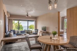 a living room with a couch and a table and chairs at Amorita Resort Bohol in Panglao Island