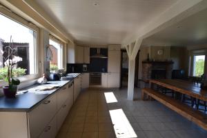 a kitchen with white cabinets and a wooden table at Aan de Vleterbeke in Oostvleteren