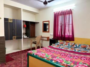 a room with a bed and a chair in a room at Aravind Guest House in Chidambaram