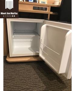 an empty refrigerator with its door open on the floor at Meet Inn Narita in Narita