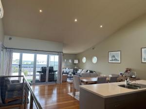 a living room with a kitchen and a living room with a table at Unit 4 The village light house in Metung
