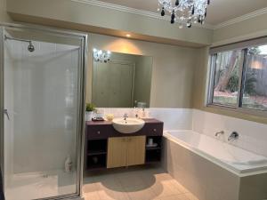 a bathroom with a tub and a sink and a shower at Unit 4 The village light house in Metung +17 photos