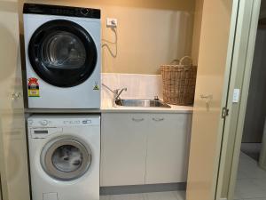 a kitchen with a washing machine and a sink at Unit 4 The village light house in Metung