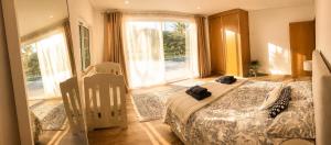 a bedroom with a bed and a large window at Préfacio Do Silêncio in Godinhaços +28 photos