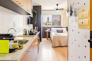 a kitchen with a sink and a living room at Studio Luar 611: Executivo Premium - SmartPituba in Salvador