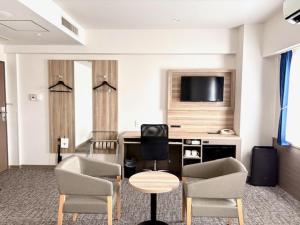 a hotel room with a table and chairs and a television at Smile Hotel Kitaasaka in Asaka +23 photos