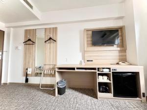 a room with a flat screen tv in a living room at Smile Hotel Kitaasaka in Asaka