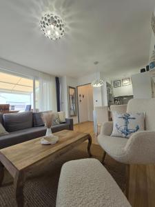 a living room with a couch and a table and chairs at Apartman Oscar with pool access in Petrcane