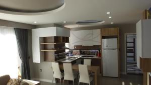 a kitchen with a wooden table and white chairs at Han-De Homes in Kemer