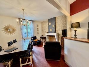a living room with a table and a dining room at Le Clos des Lys, Maison de Pays Raffinée Proche de la Mer in Saint-Georges-dʼOléron