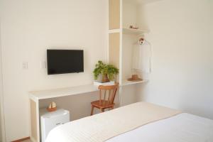 a bedroom with a bed and a tv on a wall at Casa Aia - Hospedagem de Charme na Atalaia in Aracaju