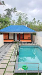 a house with a swimming pool in front of it at The Royal Pool Resort-Swimming Pool Resort, Varkala in Varkala +12 photos