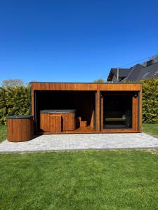 a wooden house with a patio in a yard at Przystanek Wyspa in Gdańsk