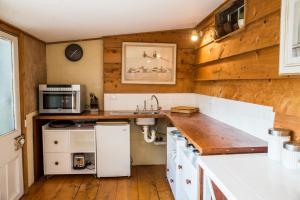 a kitchen with white appliances and wooden walls at Mrs Banks in Robe +8 photos