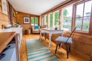 a kitchen with a table and chairs and windows at Mrs Banks in Robe