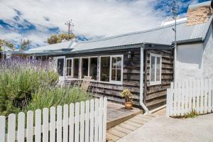 a wooden house with a white fence in front of it at Mrs Banks in Robe
