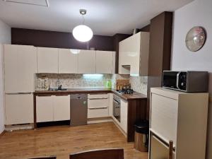 a kitchen with white cabinets and a microwave at Kuca Kosta in Pale