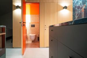 a bathroom with a toilet in a room with wooden cabinets at Ferienapartment OVIX in Okrug Donji +23 photos