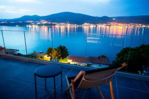 a balcony with a bar stool and a view of the water at Ferienapartment OVIX in Okrug Donji