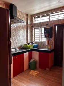 a kitchen with red cabinets and a black counter top at Niyor Nest in Guwahati