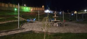 a park at night with a fountain in the middle at Bam Asia Five Star Hotel in Bāmīān