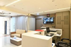 an office with a desk with a computer and a tv at Hotel Crystal in Ahmedabad