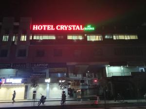 a building with a hotel cyritial sign at night at Hotel Crystal in Ahmedabad
