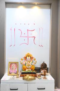 a wall with a sign and a statue on a dresser at Hotel Crystal in Ahmedabad
