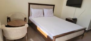 a bedroom with a bed and a table and chairs at Bam Asia Five Star Hotel in Bāmīān
