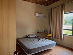 a small bedroom with a bed and a window at villa 911 in Pacific Harbour