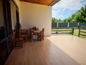 a patio with a table and chairs and a fence at villa 911 in Pacific Harbour