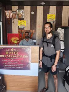 a man standing in front of a hotel fireenna inn at Hotel Shree Sanwaliya INN in Ayodhya