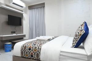 a bedroom with a bed with a tv on the wall at Hotel Crystal in Ahmedabad +18 photos