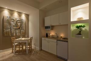 a kitchen with a table and a painting of a head at Aruna Suites in Rome