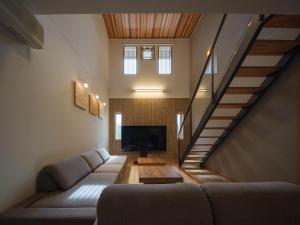 a living room with a couch and a tv at マークヴィラ松本 in Matsumoto