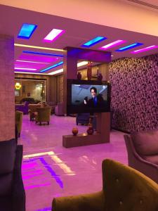 un soggiorno con TV e illuminazione viola di Rukon Buotat 15 a Riyad
