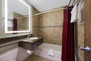 a bathroom with a tub and a toilet and a sink at Rodeway Inn South San Francisco Airport in South San Francisco +39 photos