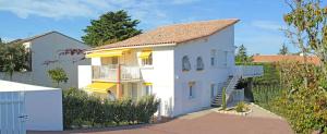 a white house with a balcony and a fence at Hôtel Résidence Les Flots in Saint-Palais-sur-Mer