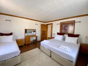 a bedroom with two beds and a mirror at Sunset House in Selçuk
