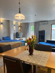 a room with a table with a vase of flowers on it at Villa Meri Apartments in Pärnu