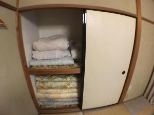 a closet with a stack of folded towels at Guest House Atagoya in Kyoto