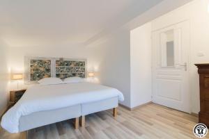 a white bedroom with a white bed and a window at Le cerisier - château des varennes in Varennes +26 photos