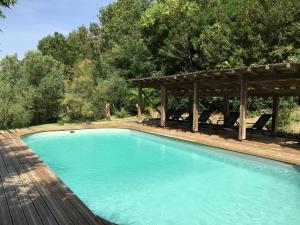 a swimming pool with a gazebo and chairs at Le cerisier - château des varennes in Varennes