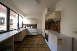 a small kitchen with white appliances and a window at Spacious Apartment at Top Location Grote Markt in Sint-Niklaas
