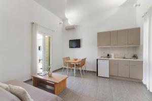 a living room with a kitchen and a table at LausAndros Suites in Andros